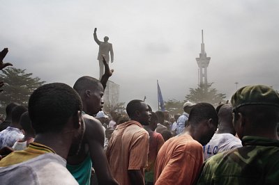 A statue of Patrice Lumumba erected by Laurent Kabila, and an unfinished tower built during the Mobutu years, look down on Jean-Pierre Bemba supporters as they make their way to a rally, Kinshasa, 2006